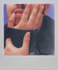 a polaroid photo of a man with his hand on his face