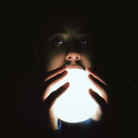 a person holding a glowing ball in their hand